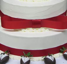 tuxedo strawberries and red ribbon wedding cake