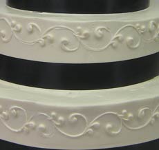 white scrolling with black ribbon wedding cake