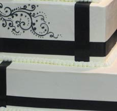 square tiered white wedding cake with ribbon